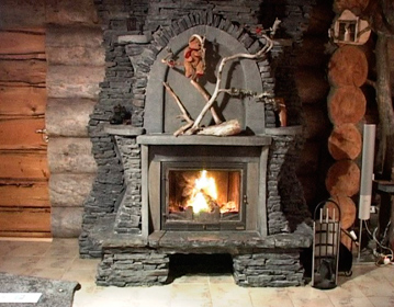 камин с развёрнутой топкой с  облицовкой из  камня с панно и полкой из  камня 