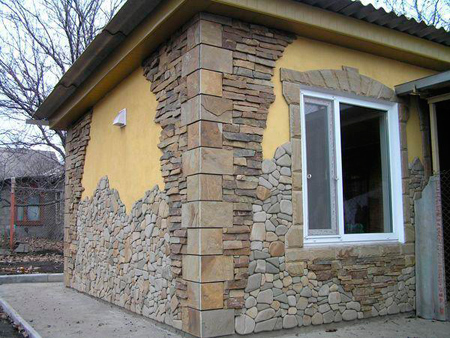  художественная композиция из  камней   на  фасаде здания 